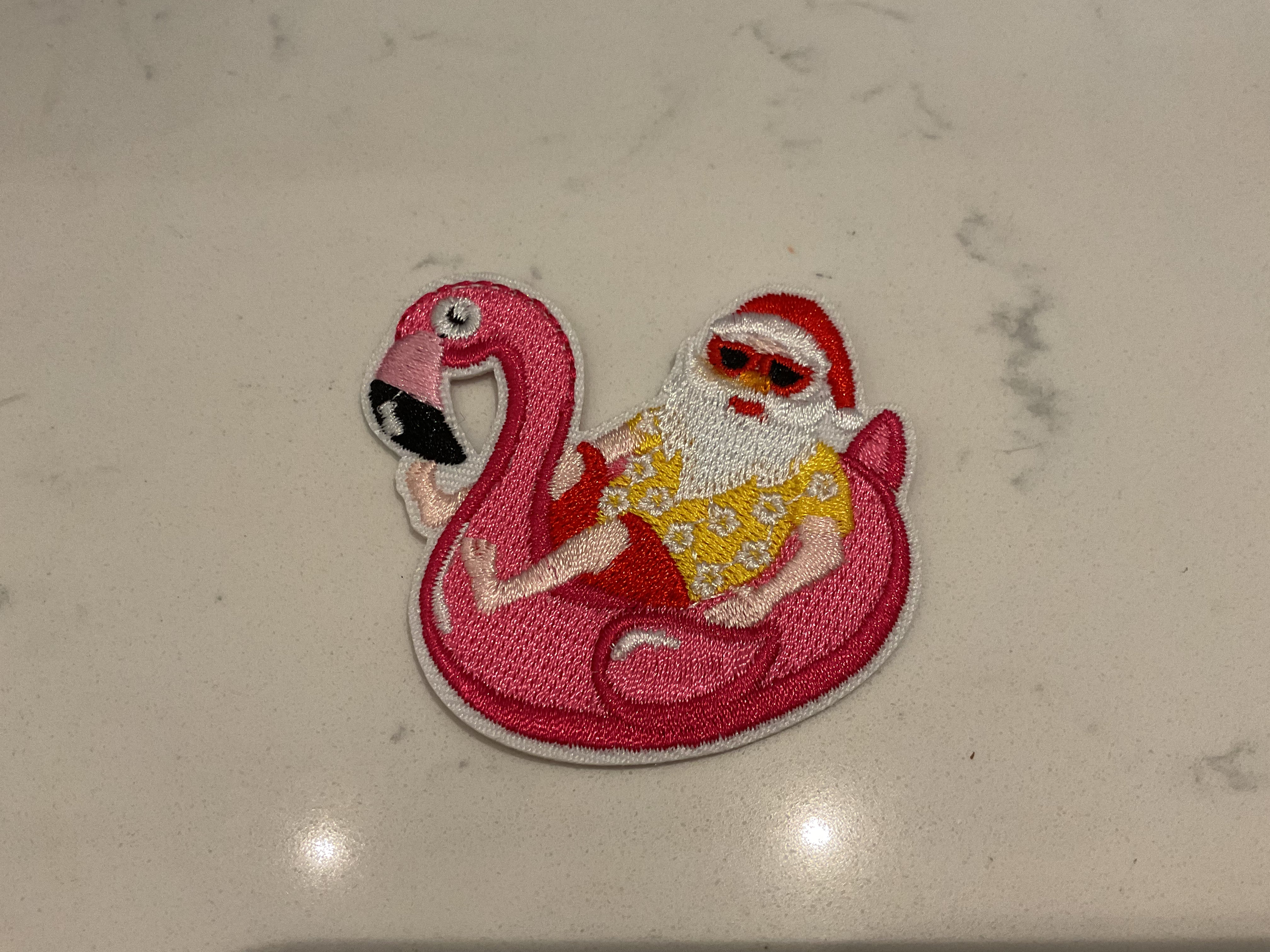 Santa laying in a flamingo floaty patch