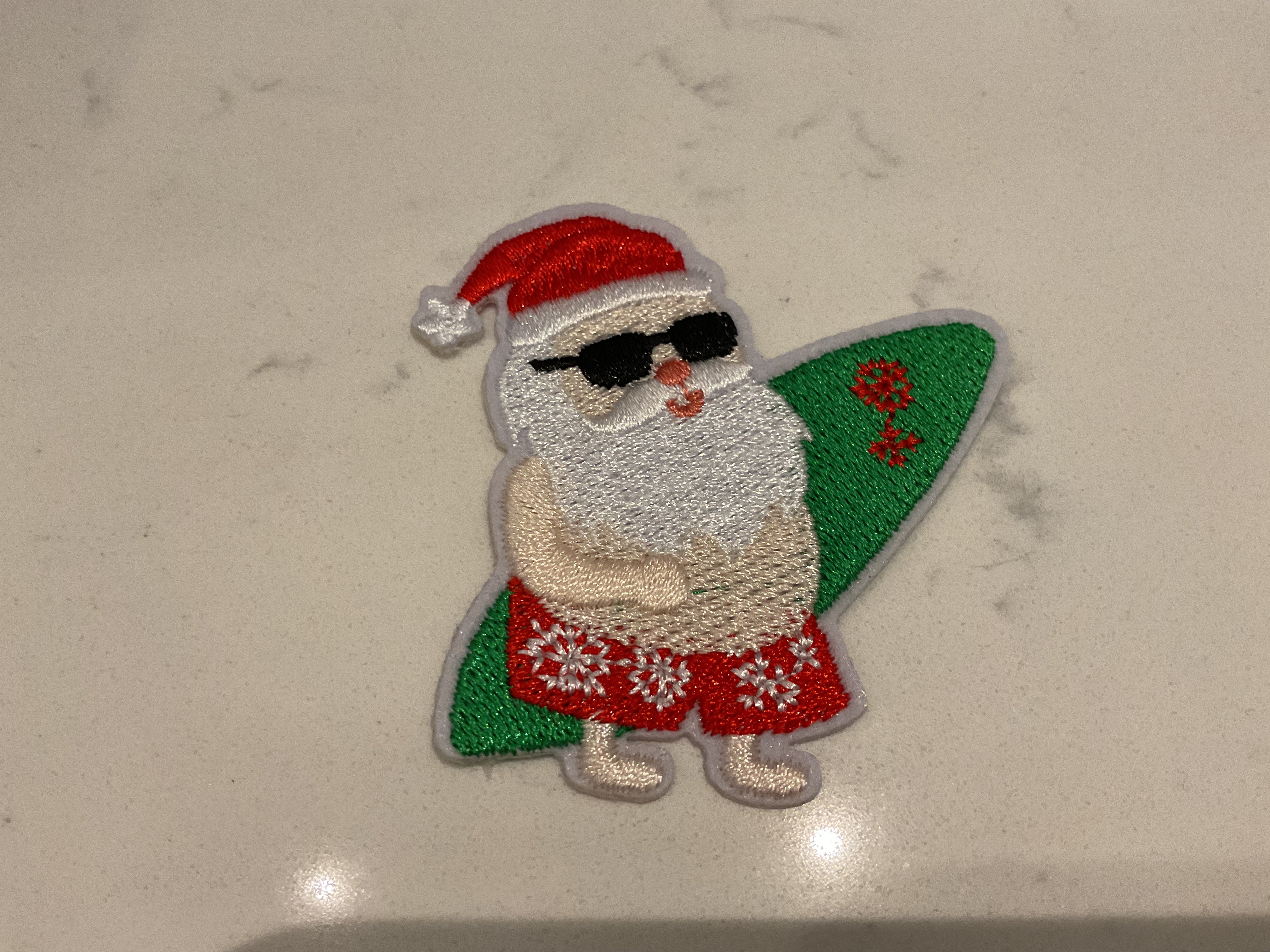 Santa holding a green surfboard patch