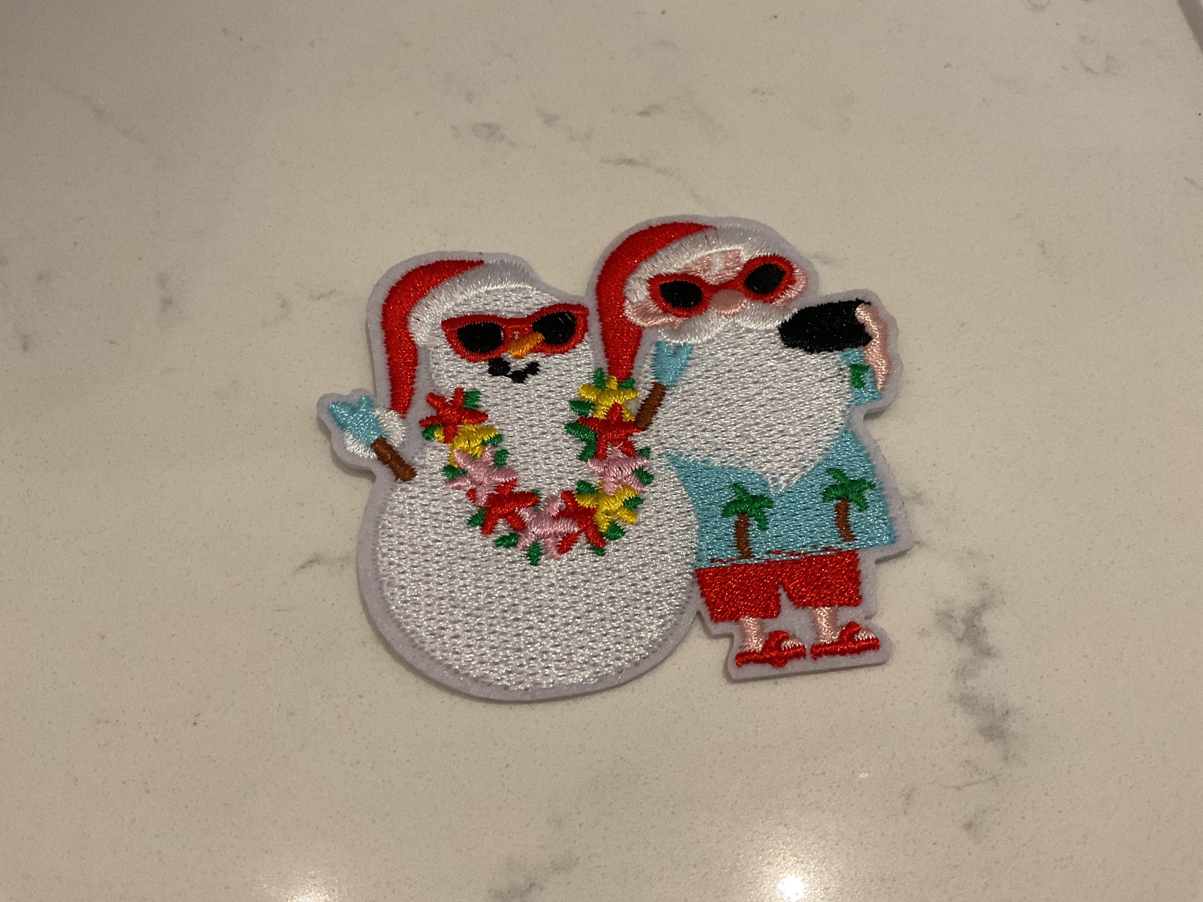 Santa taking a photo with a snowman patch