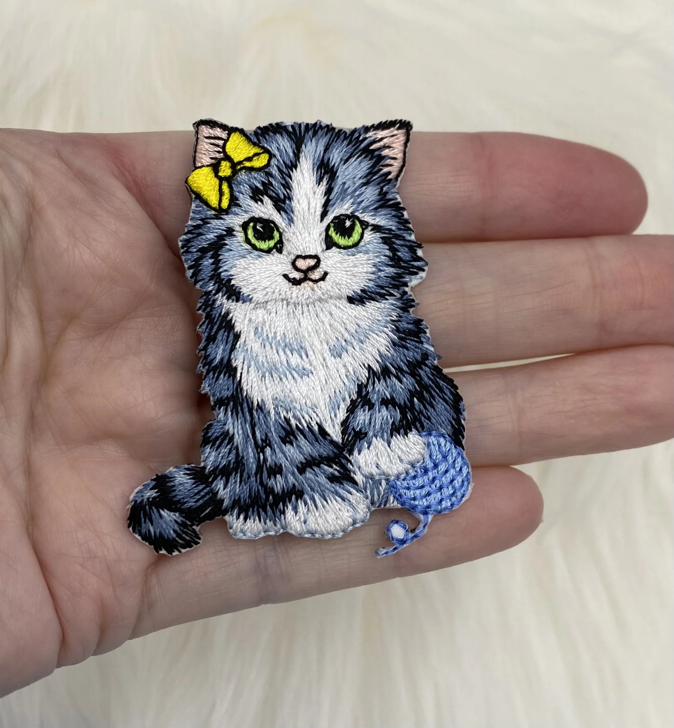 Cat with yarn and yellow bow patch