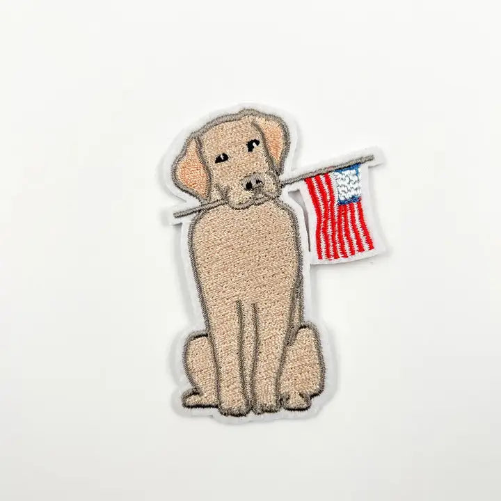 Yellow lab holding American flag patch