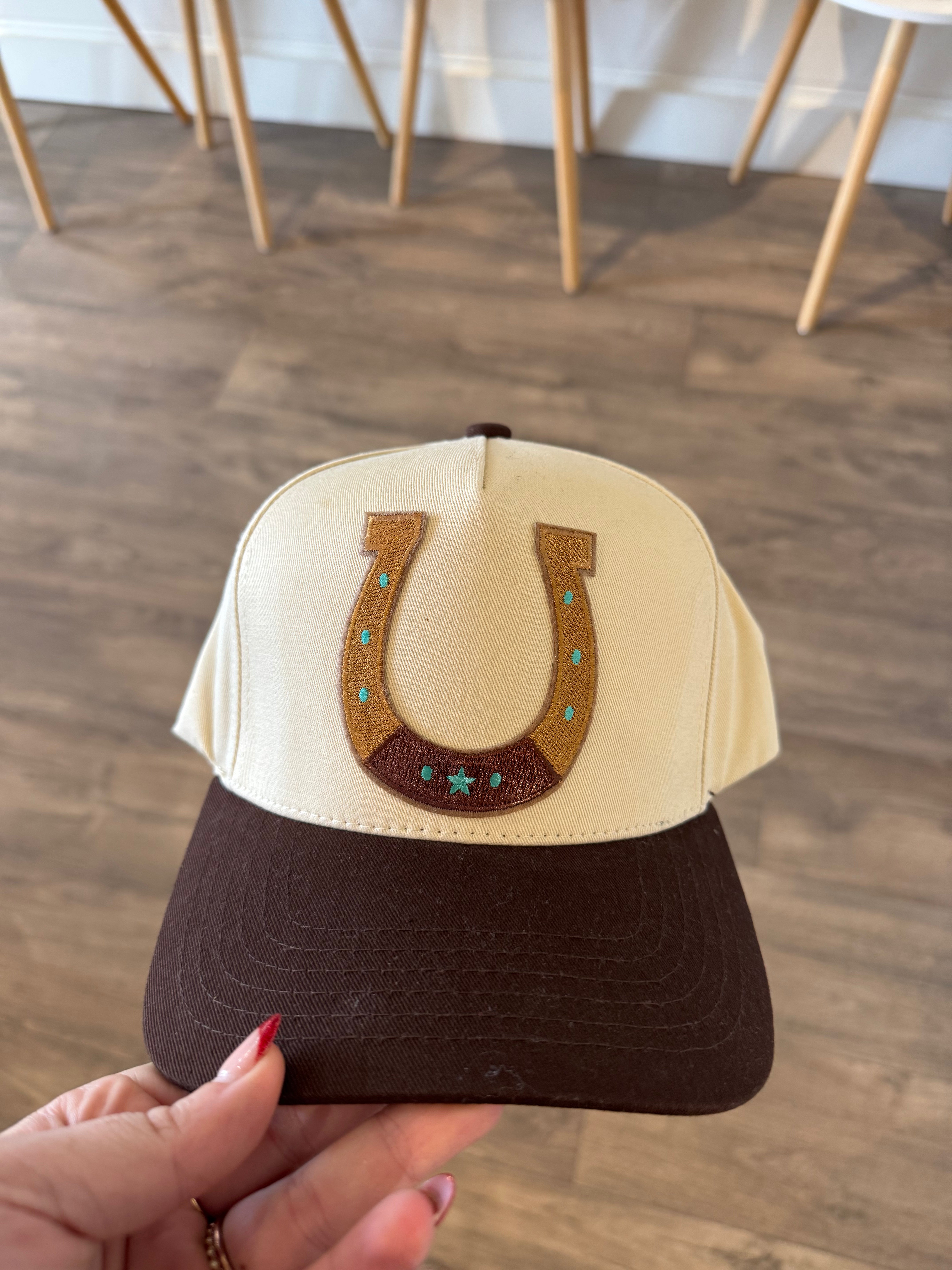 Brown two tone canvas trucker hat with horseshoe patch
